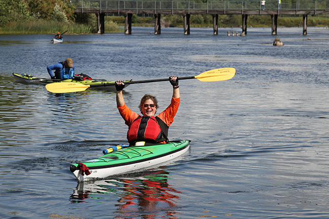 Paddle Antrim kayaker with arms raised about head.