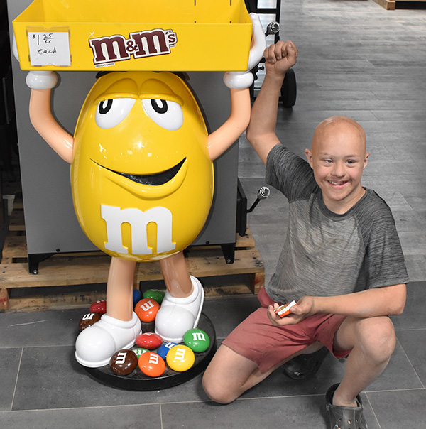Boy kneeling next to M&M character