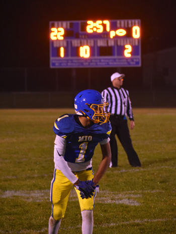 Mio football player lining up with scoreboard in background