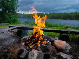 Campfire burning with a lake in the background