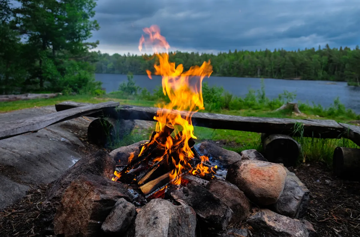 Campfire burning with a lake in the background