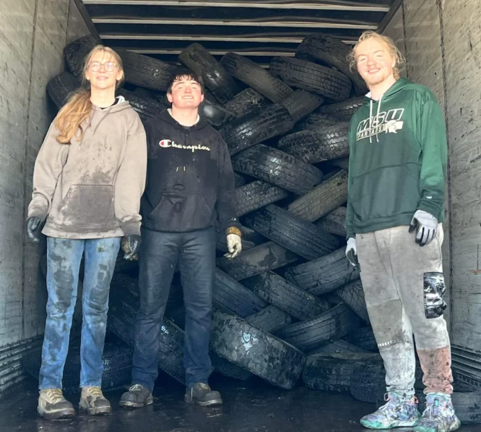 kids standing in back up truck after stacking tires
