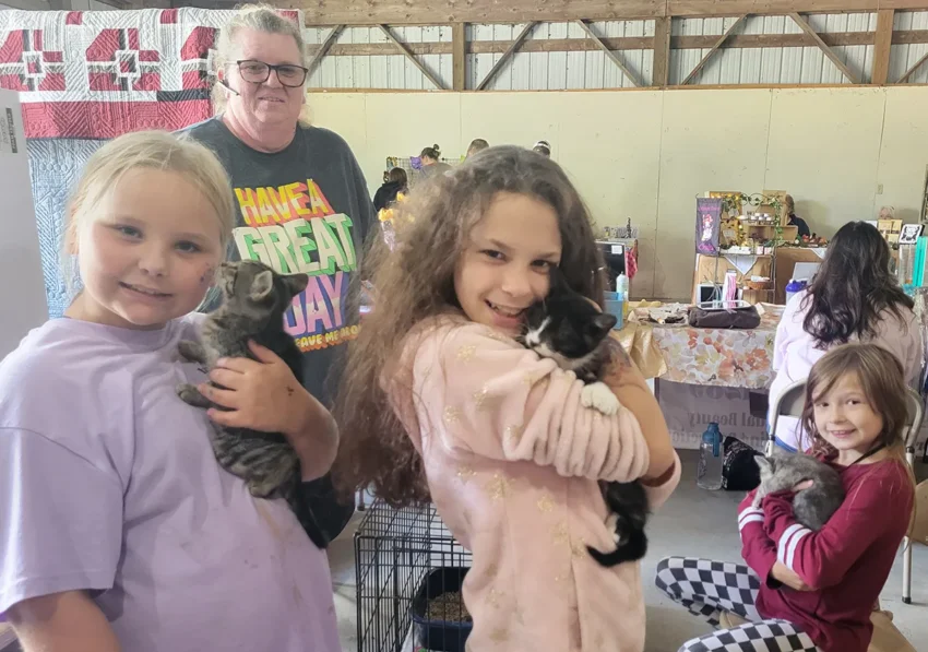 Cloe Higgins, Kenlea Schroeder, and Aria cuddling with rescued kittens