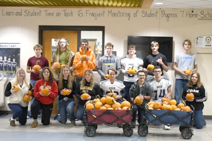 student council fund. Student Council fundraiser group posing with pumpkins