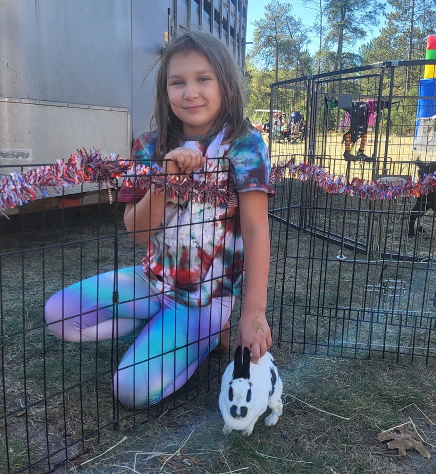 Isabel petting a rabbit in the petting zoo.