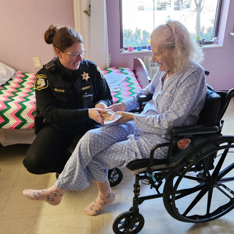 Police officer assisting senior at facility