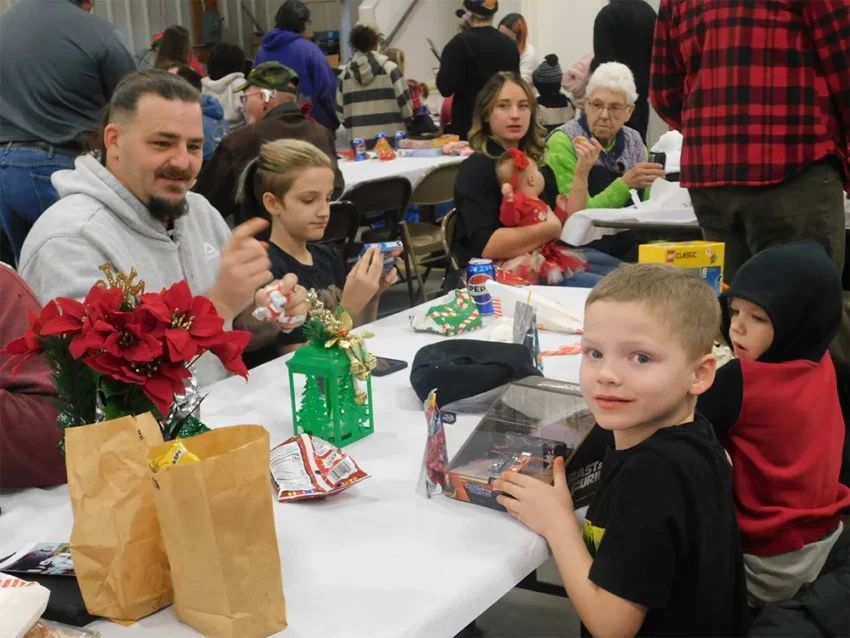 The Green, family of Prescott enjoying a meal of hotdogs Chips and a drink while opening their present from Santa Claus.