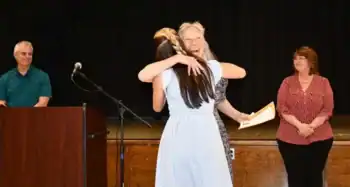 Elizabeth Wolainin receiving a warm hug and scholarship from the Hale Area Education Foundation.