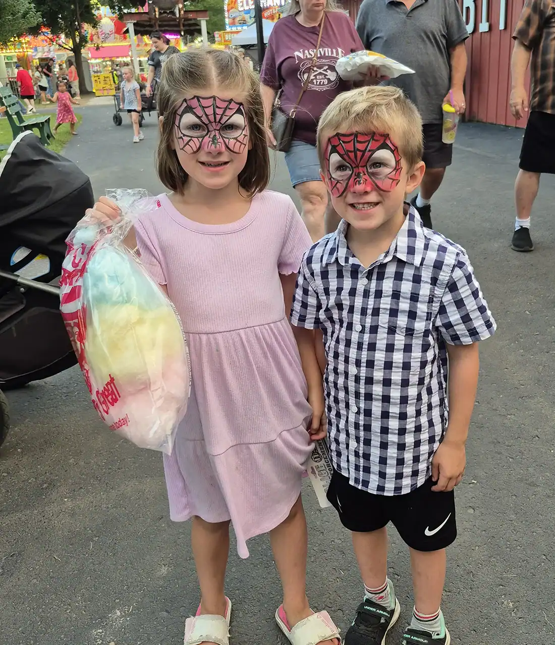 Natalie Whitney (6) and Liam Brown (6) taking a break from riding rides to eat some cotton candy.
