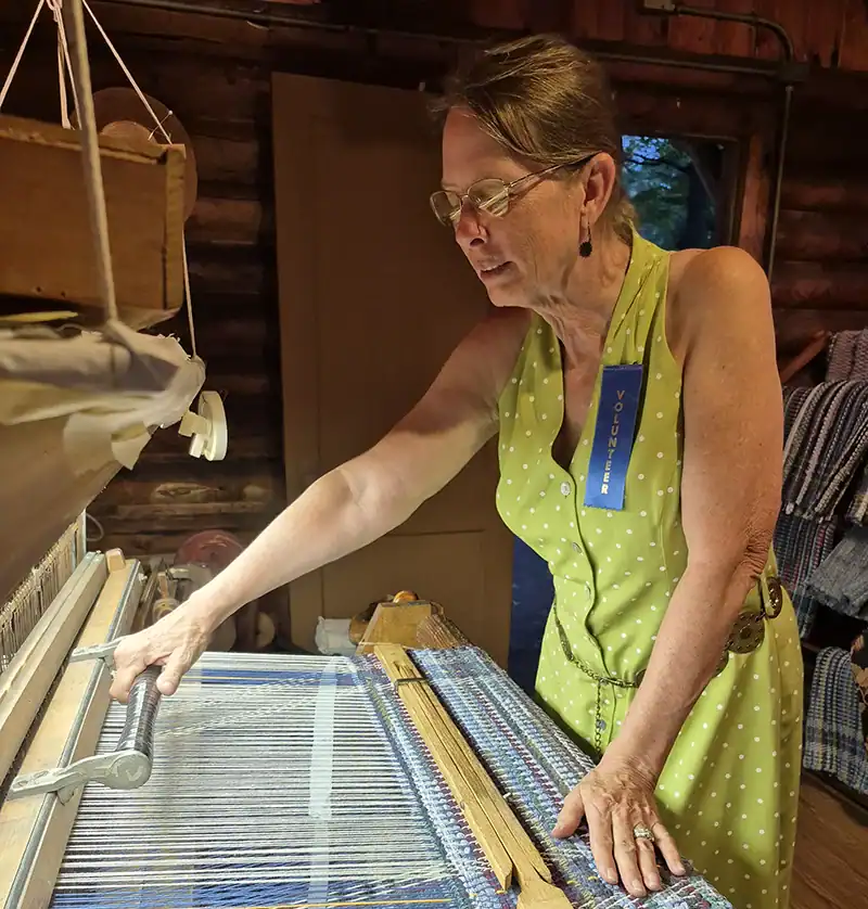 Marcia Doss of Dragon's Meadow Farm demonstrating how to weave a rug on a rug loom.