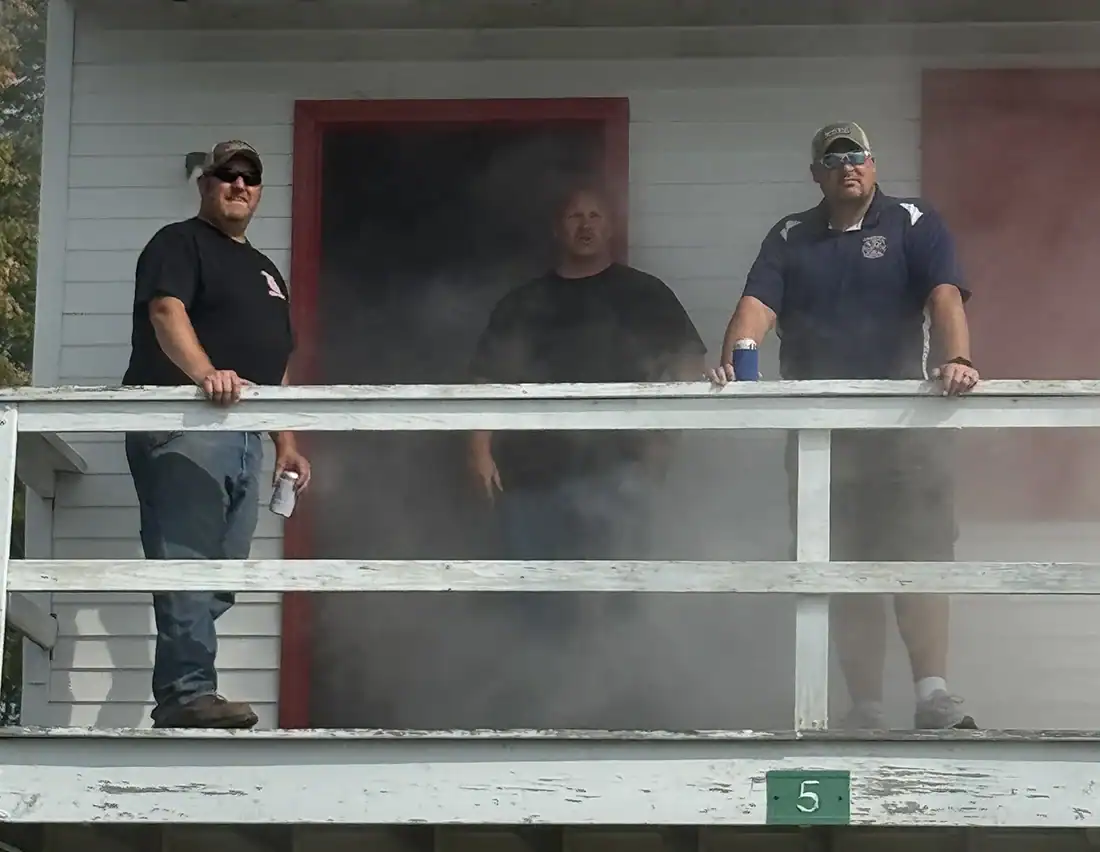 men standing outside of smoke training building