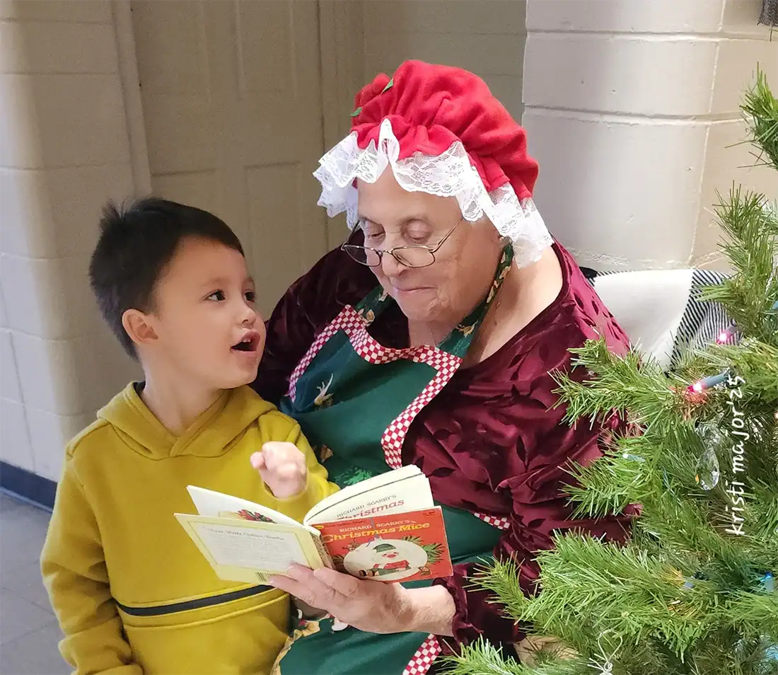 At the Hale Senior Centers Christmas Bazaar, Mrs. Claus (Hale resident Lucille Lauria) reads to young Emerick Lincoln of Flushing.